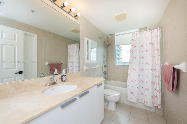 full bathroom featuring tile patterned flooring, vanity, tile walls, toilet, and shower / bath combo with shower curtain