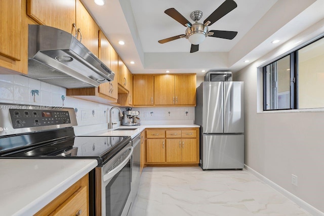 kitchen with ceiling fan, appliances with stainless steel finishes, decorative backsplash, range hood, and sink