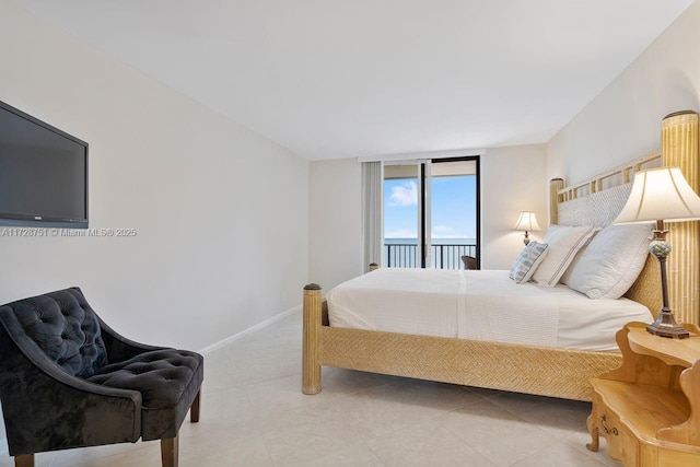 tiled bedroom featuring a wall of windows and access to outside