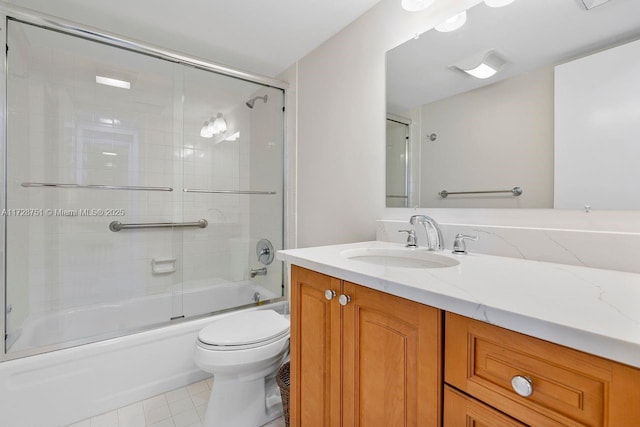 full bathroom featuring combined bath / shower with glass door, vanity, tile patterned floors, and toilet