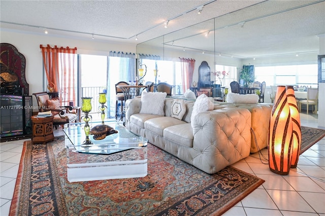 living room with track lighting, a textured ceiling, and light tile patterned floors