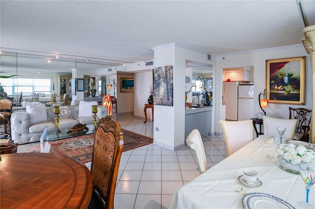 tiled dining room featuring ornamental molding and a textured ceiling