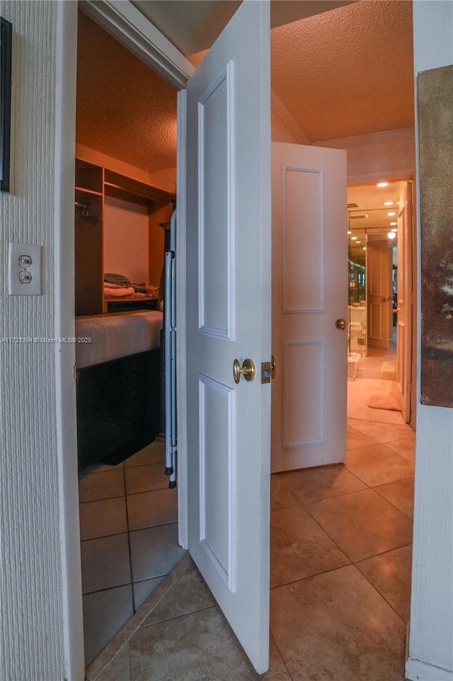 hall featuring tile patterned floors and a textured ceiling