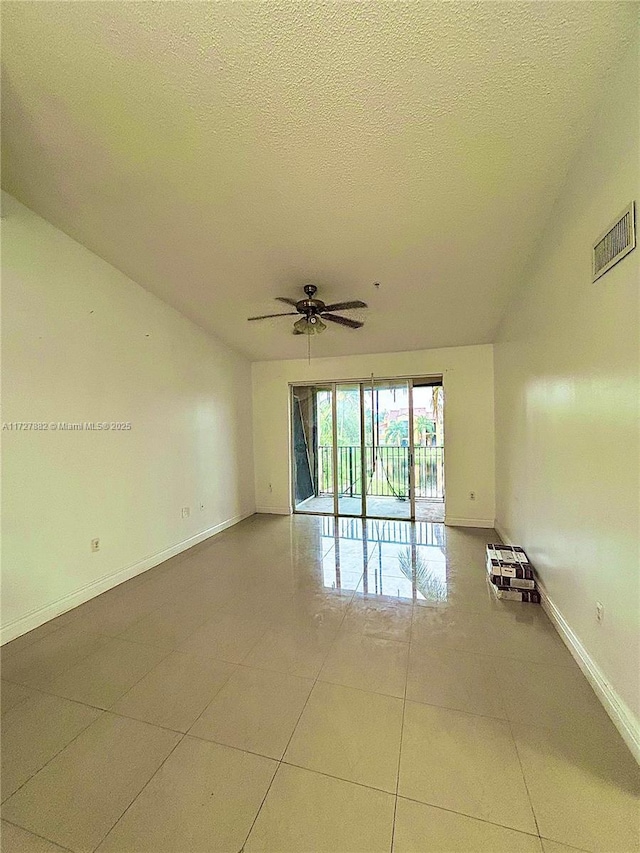 tiled spare room featuring ceiling fan and a textured ceiling