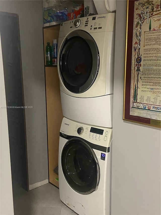 washroom featuring light tile patterned floors and stacked washer and clothes dryer