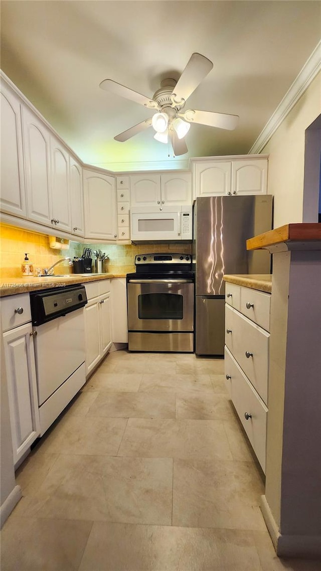 kitchen featuring stainless steel appliances, crown molding, backsplash, and white cabinetry