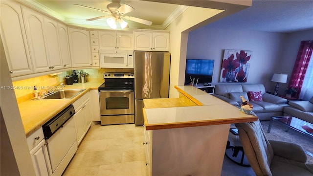 kitchen with white cabinetry, kitchen peninsula, appliances with stainless steel finishes, crown molding, and sink