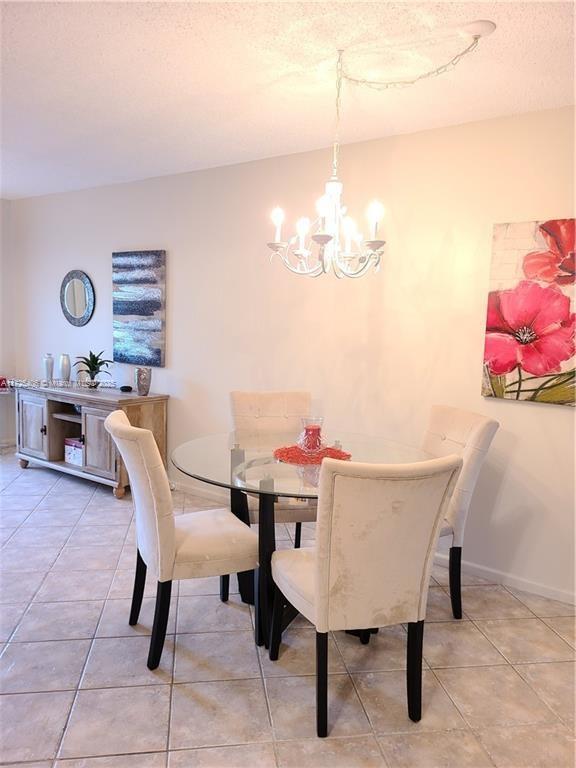 dining space featuring tile patterned flooring and an inviting chandelier