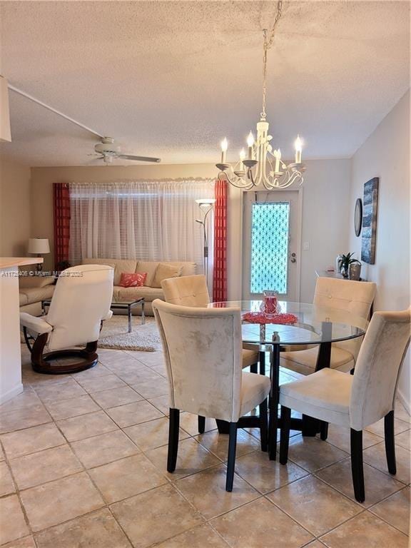 dining room featuring a textured ceiling, light tile patterned floors, and ceiling fan with notable chandelier