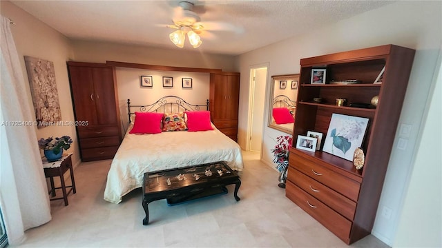 bedroom featuring ceiling fan and a textured ceiling