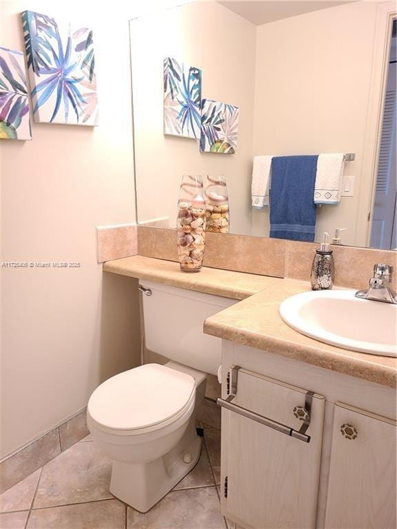 bathroom featuring toilet, vanity, and tile patterned flooring