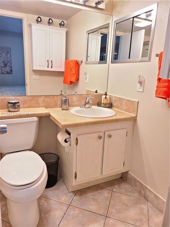 bathroom featuring toilet, tile patterned flooring, and vanity