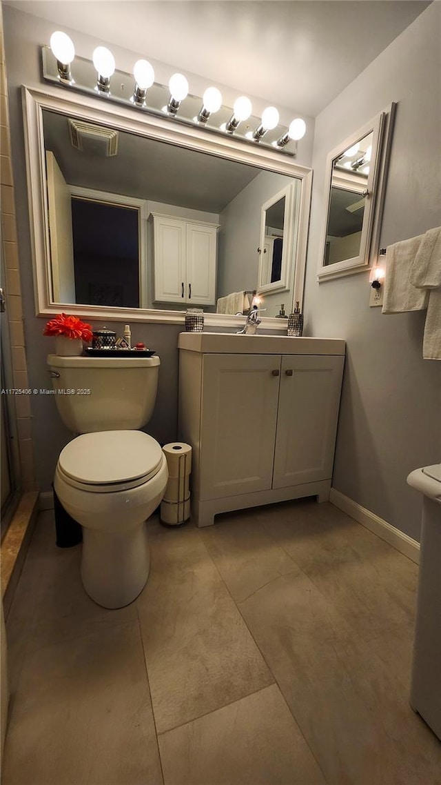 bathroom with toilet, tile patterned flooring, and vanity