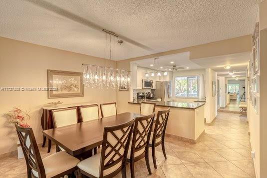 dining room featuring a textured ceiling and light tile patterned floors