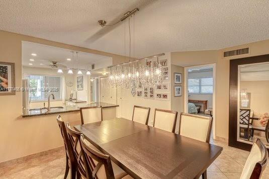 dining room featuring a textured ceiling, ceiling fan, and light tile patterned flooring