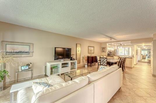 living room featuring a textured ceiling and light tile patterned floors