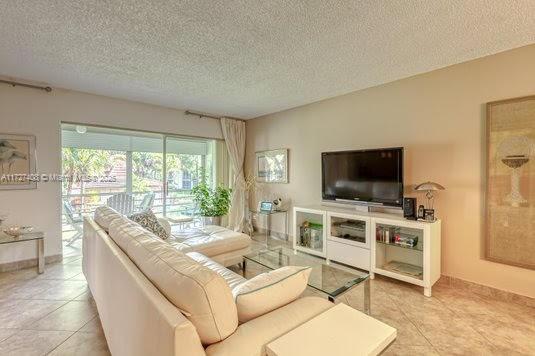 tiled living room featuring a textured ceiling