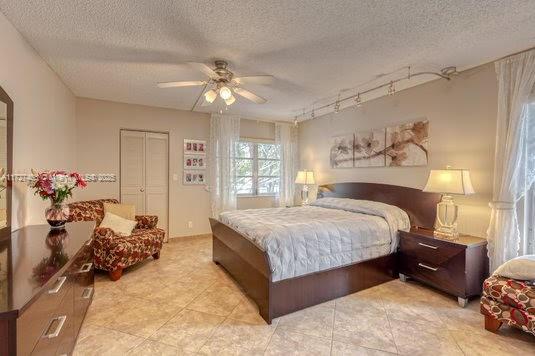 bedroom featuring a textured ceiling, ceiling fan, and a closet