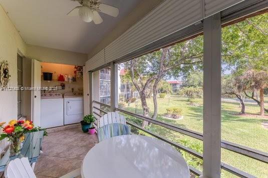 sunroom / solarium featuring ceiling fan and washing machine and clothes dryer