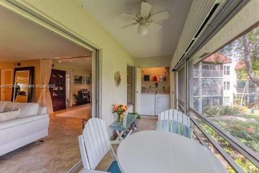 sunroom featuring ceiling fan and washing machine and dryer