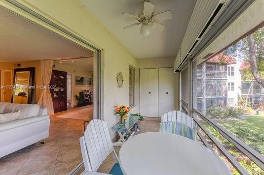 sunroom / solarium featuring ceiling fan