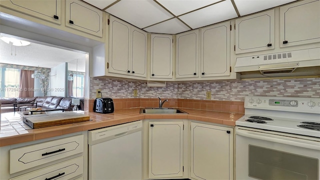 kitchen with tile counters, sink, white appliances, and tasteful backsplash