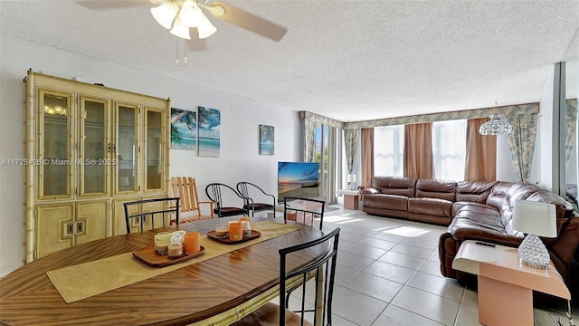 tiled dining space with ceiling fan and a textured ceiling