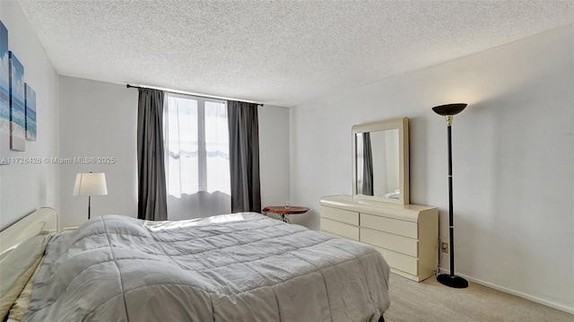 bedroom featuring a textured ceiling and light carpet