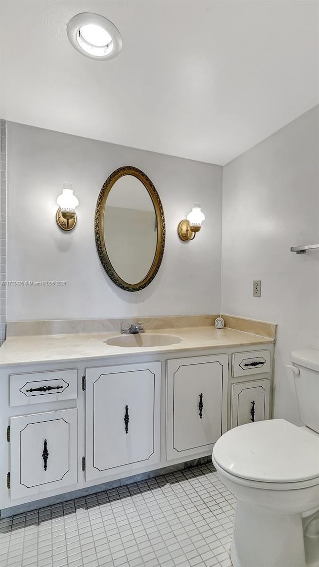 bathroom with toilet, tile patterned floors, and vanity