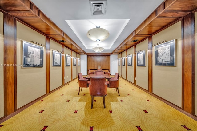 unfurnished dining area with light colored carpet and a raised ceiling