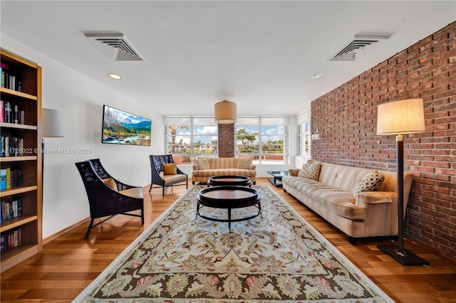 living room with wood-type flooring and brick wall