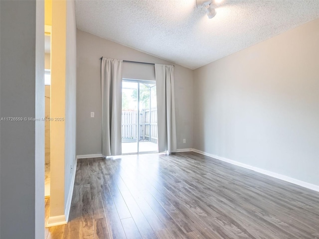 unfurnished room featuring hardwood / wood-style flooring, lofted ceiling, and a textured ceiling