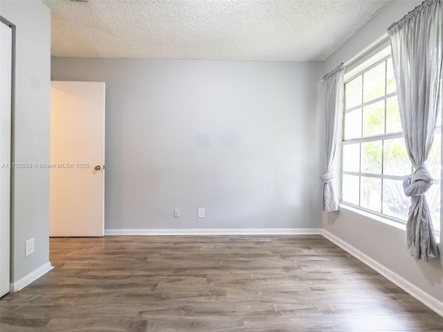 unfurnished room with hardwood / wood-style floors and a textured ceiling