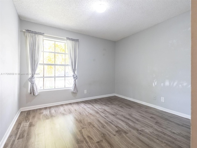 empty room featuring hardwood / wood-style flooring and a textured ceiling