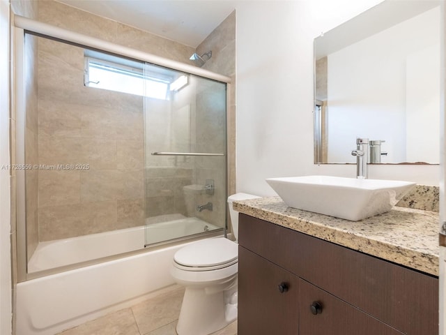 full bathroom featuring enclosed tub / shower combo, vanity, tile patterned floors, and toilet