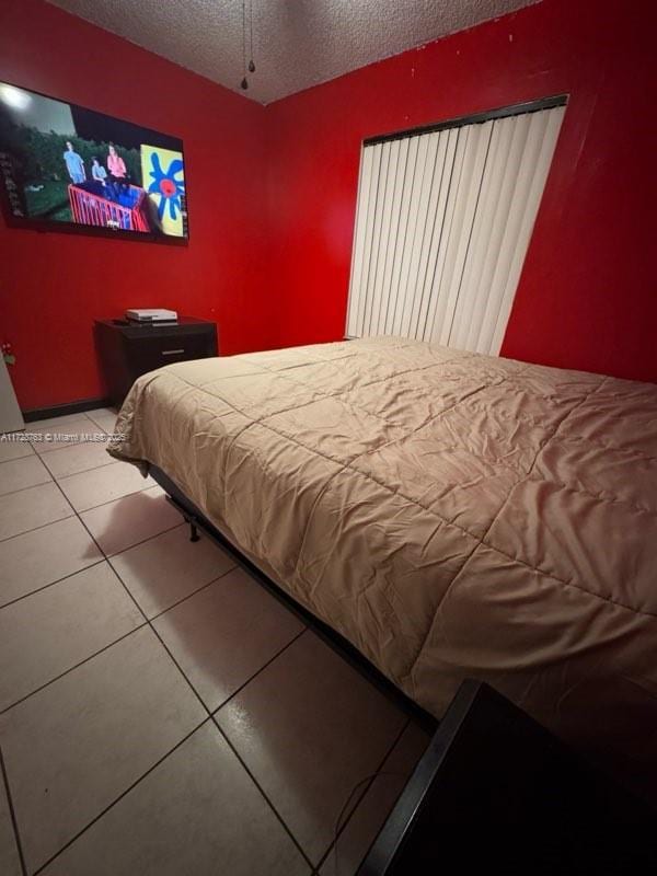 tiled bedroom featuring a textured ceiling