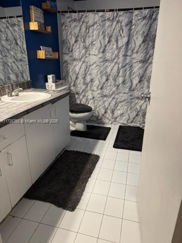 bathroom featuring toilet, a shower with shower curtain, tile patterned flooring, and vanity