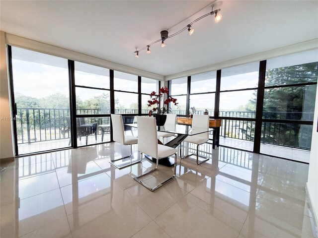 unfurnished dining area with a wall of windows, light tile patterned flooring, and a healthy amount of sunlight