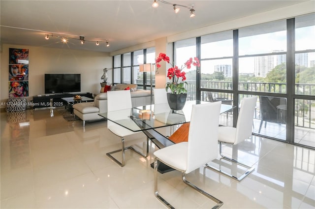 dining room featuring a wall of windows and light tile patterned floors