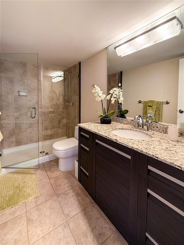 bathroom featuring toilet, vanity, tile patterned floors, and walk in shower