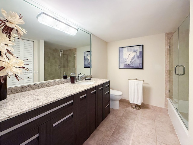 bathroom with toilet, vanity, and tile patterned flooring