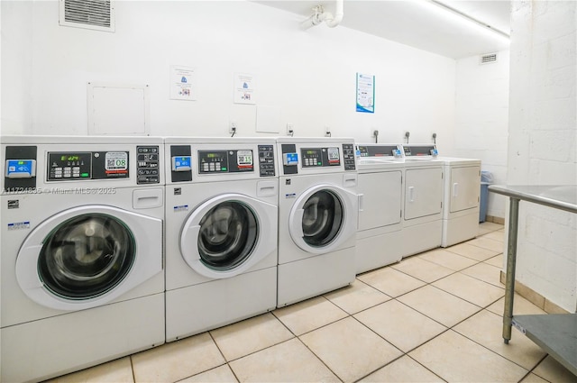 clothes washing area with light tile patterned flooring and washing machine and clothes dryer