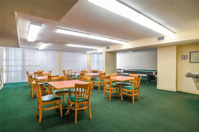 carpeted dining room with a textured ceiling