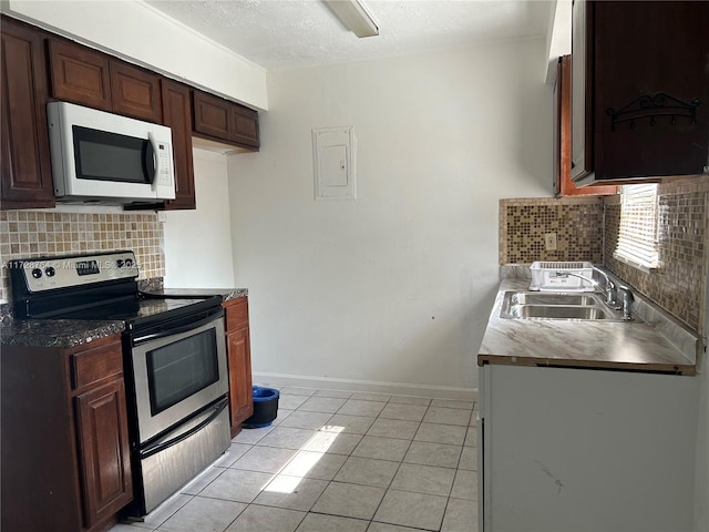 kitchen featuring tasteful backsplash, electric range, light tile patterned flooring, a textured ceiling, and sink