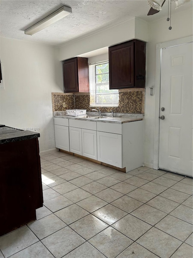 kitchen featuring tasteful backsplash, ceiling fan, sink, white cabinetry, and a textured ceiling