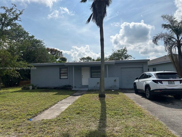 single story home featuring a front yard and a garage