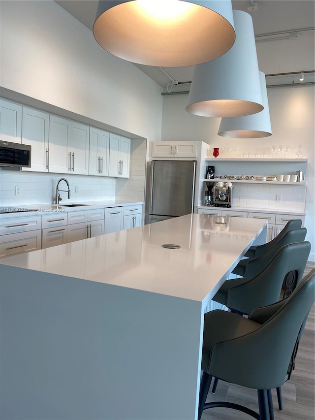 kitchen featuring a kitchen bar, white cabinetry, and stainless steel appliances