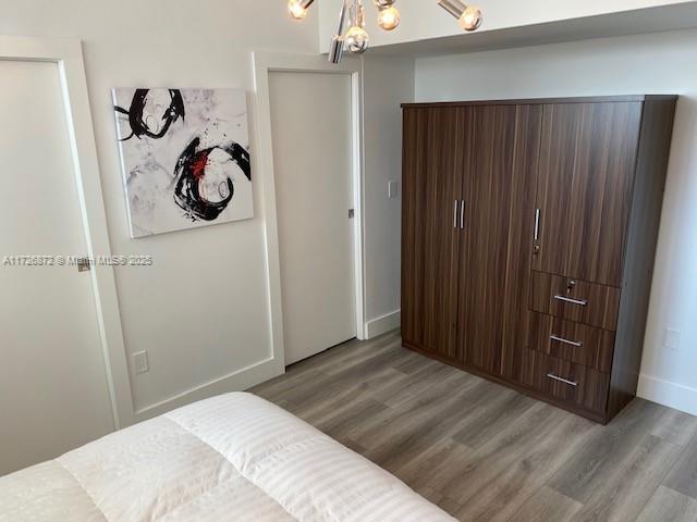 bedroom with light hardwood / wood-style flooring and a chandelier