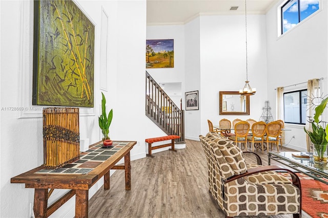 interior space with ornamental molding, a chandelier, and hardwood / wood-style flooring