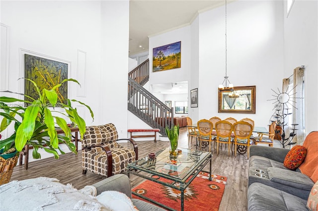 living room with a towering ceiling, hardwood / wood-style floors, and a chandelier